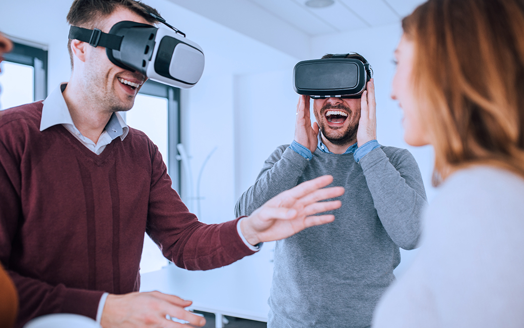 Tres personas riendo, con gafas de VR.