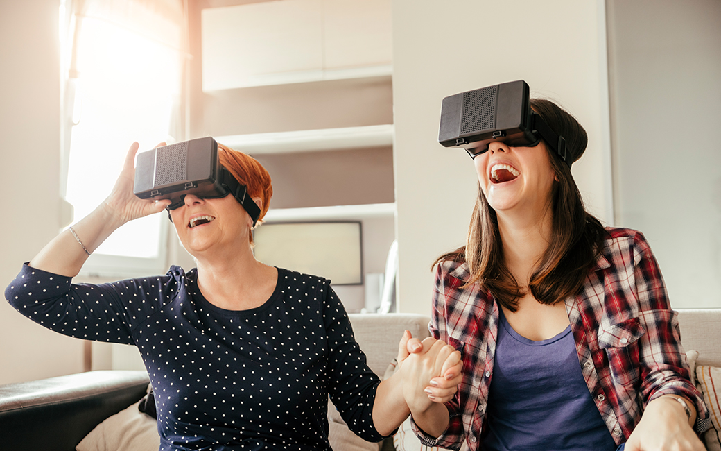 Dos personas riendo, con unas gafas de realidad virtual.