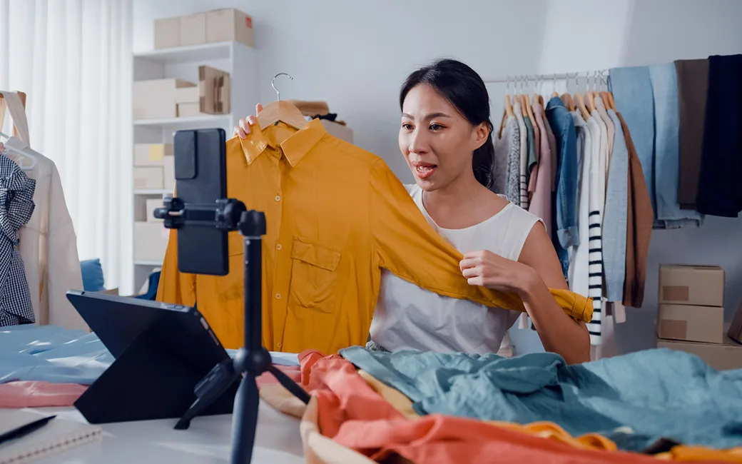 Mujer mostrando una camisa en un evento de Live Shopping.