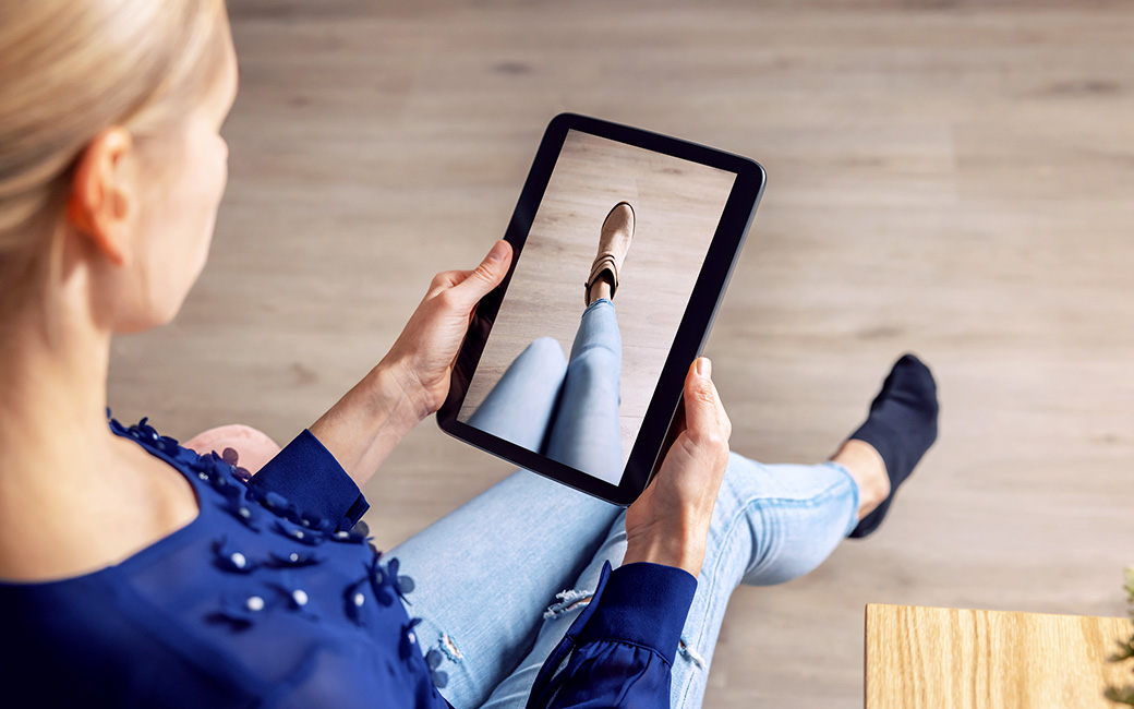 Mujer probándose un zapato a través de su tablet.