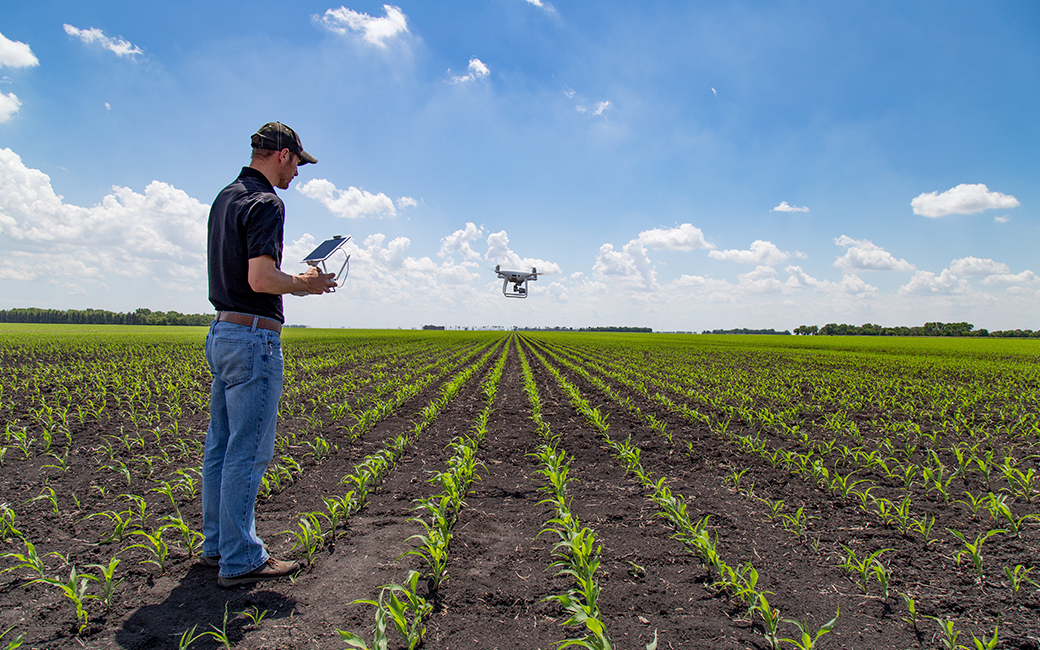 Hombre manejando dron en el campo