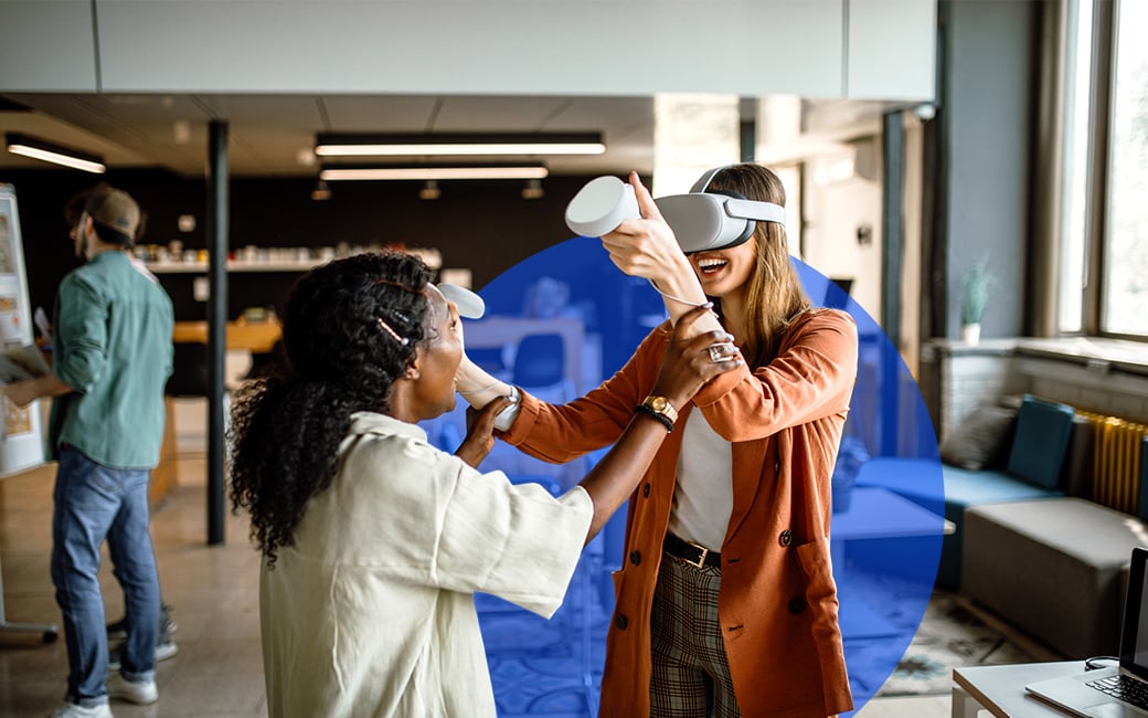 Dos mujeres en la oficina probando unas gafas de realidad virtual