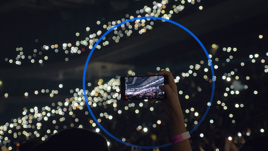 un móvil grabando un vídeo en un estadio repleto de gente