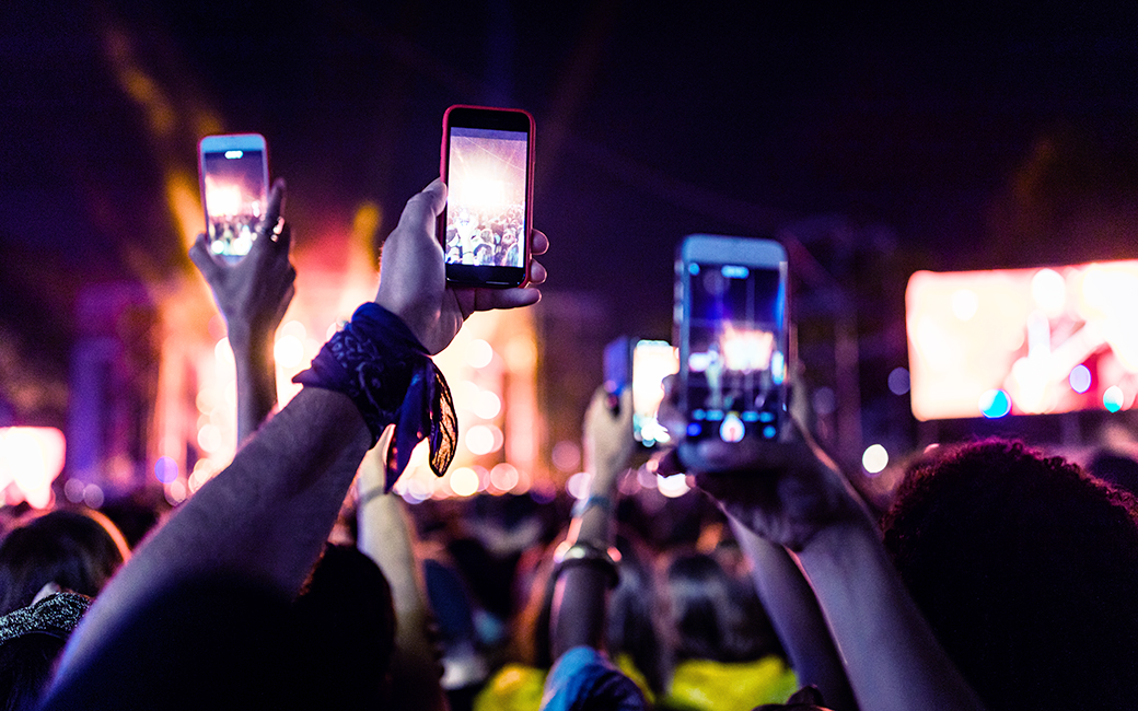 Se ve un grupo de móviles grabando contenido en un festival.