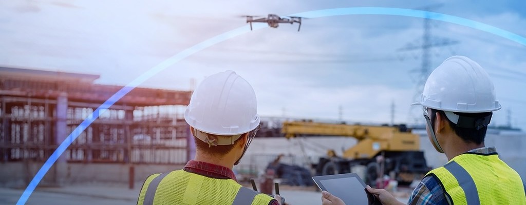 trabajadores logísticos utilizando un dron para realizar entregas