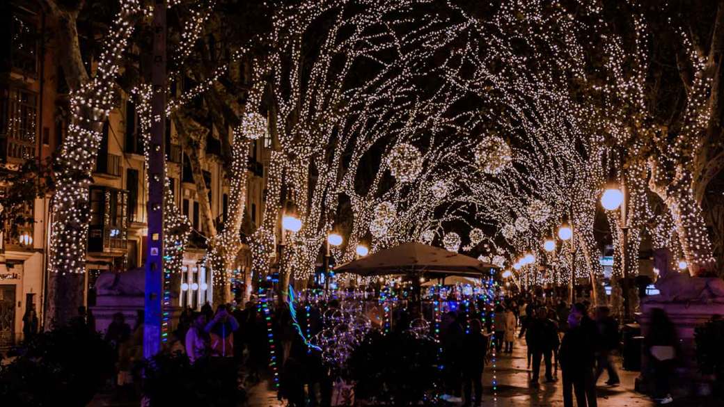 Imagen de la calle de una ciudad de noche decorada para Navidad con luces de colores.