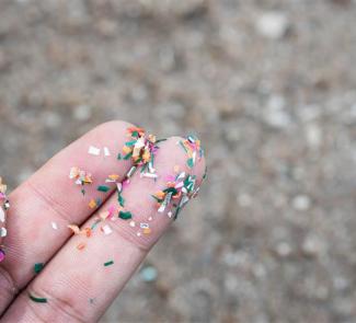 Mano con microplásticos en los dedos.