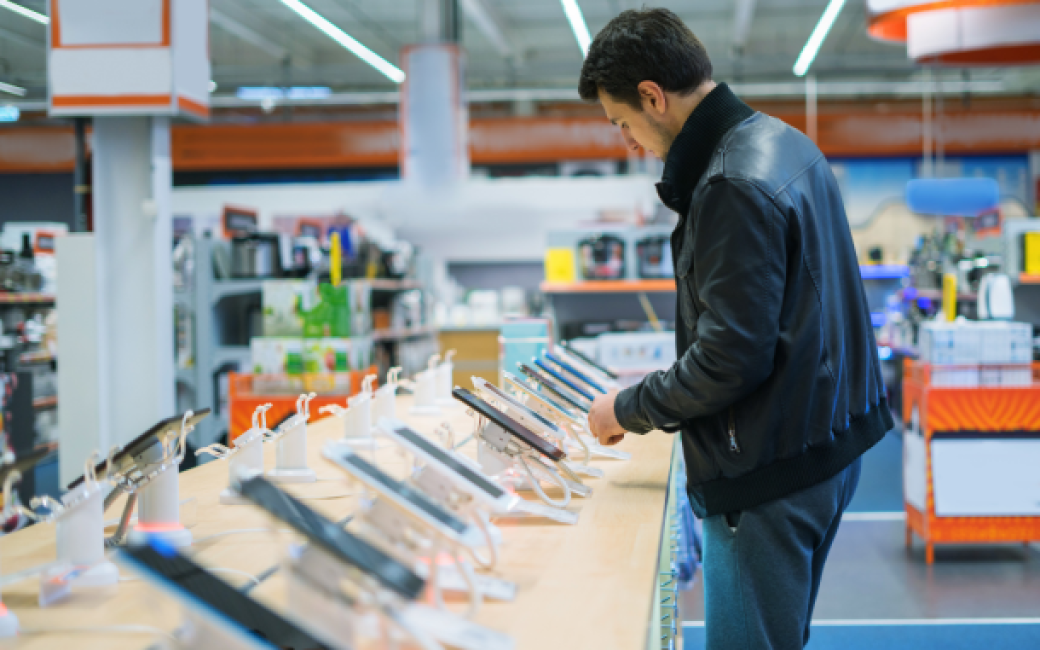 hombre mira móviles teléfonos en tienda